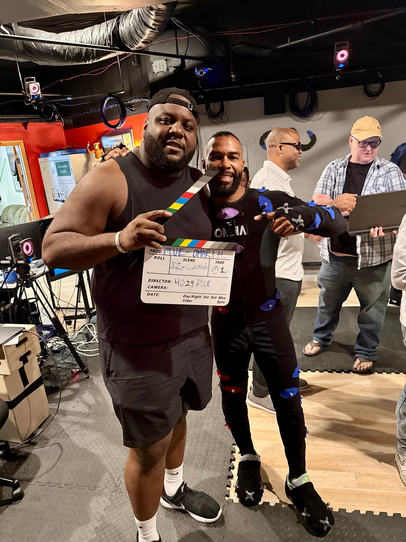 Caj Reynolds holding a production slate on a motion-capture set